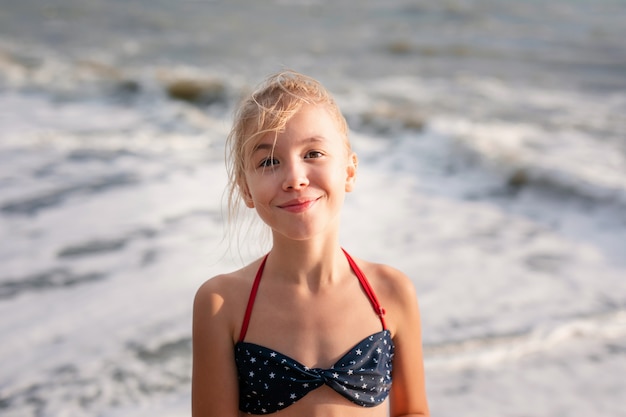 Feliz joven rubia divirtiéndose en la playa soñada con grandes olas blancas