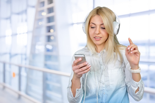 Feliz joven rubia escuchando música