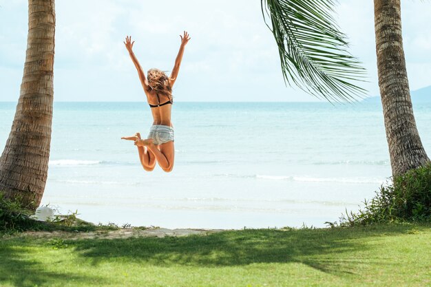 Feliz joven saltando en la playa