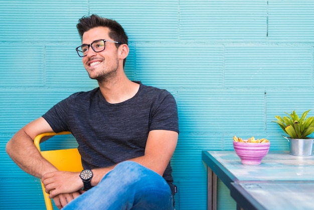 Feliz joven sentado en un restaurante