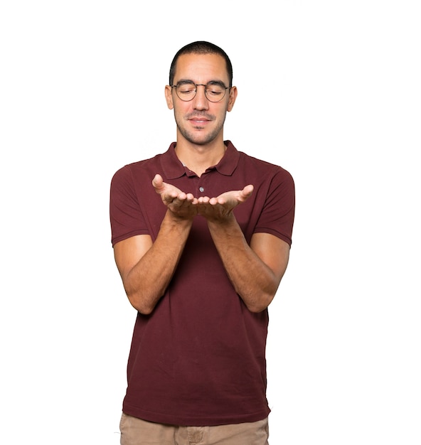 Feliz joven sosteniendo algo con la mano