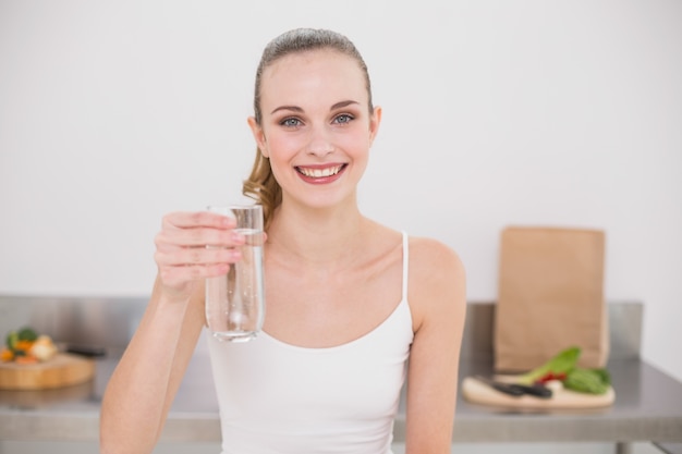 Feliz joven sosteniendo un vaso de agua