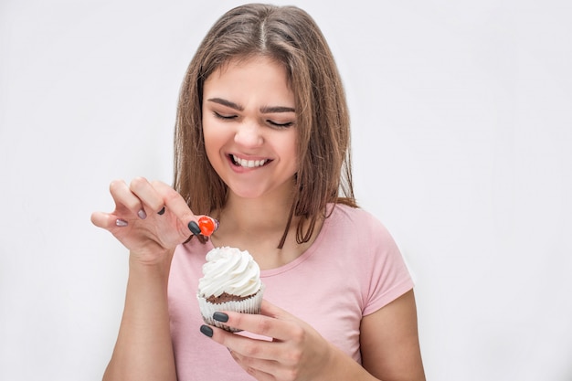 Feliz joven sostiene un pequeño cupcake