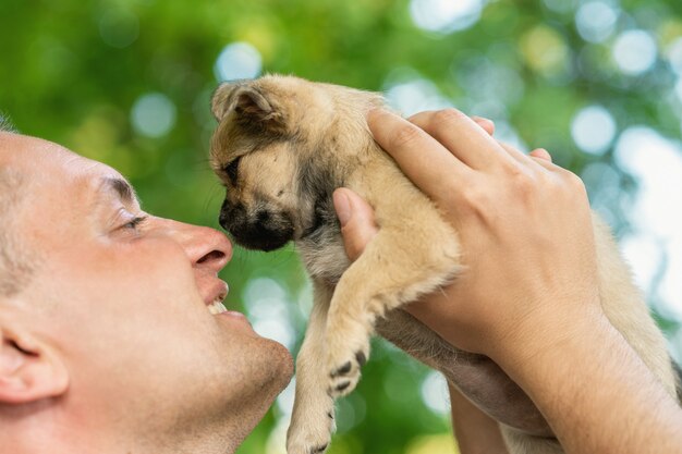 Feliz joven tocando la nariz del cachorro