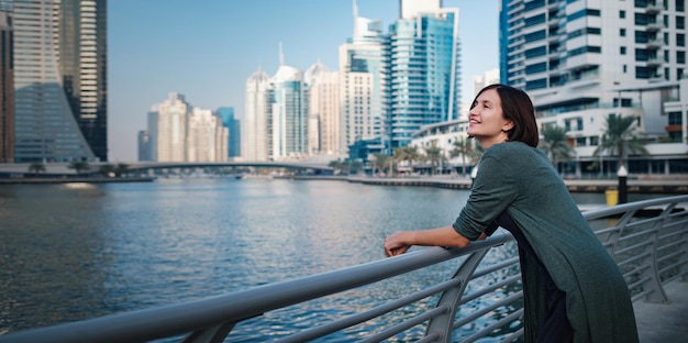 Feliz joven viajera en la gran ciudad de Dubai, Emiratos Árabes Unidos