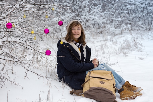 Feliz jovencita en un paseo de invierno en un día de nieve, Navidad