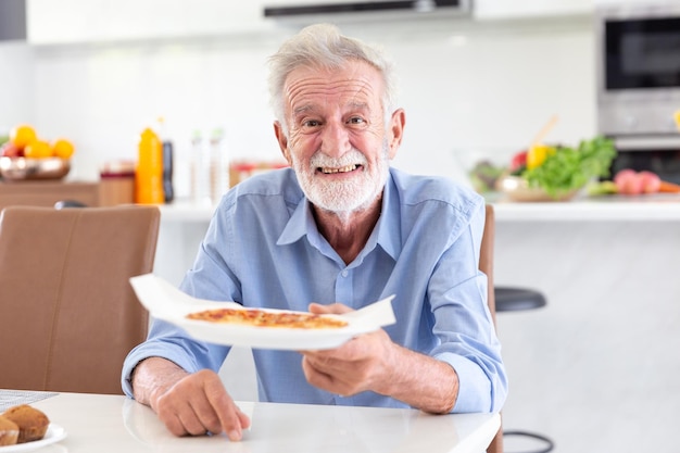 Feliz jubilación anciano sostiene pizza de horneado casero italiano de la cocina en casa de Italia