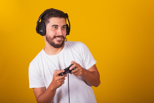 Feliz latinoamericano brasileño con auriculares y controlador de videojuegos jugando emociones disfrutando