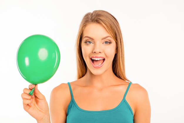 Feliz linda chica con globo verde sonriendo