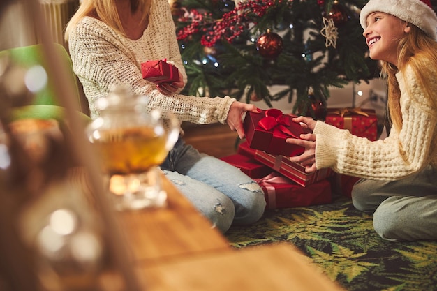 Feliz linda chica recibiendo un regalo de mamá en el Boxing Day