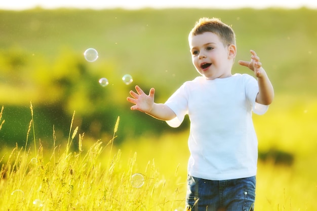 Feliz linda criança se divertir no eadow com brinquedo de bolhas de sabão