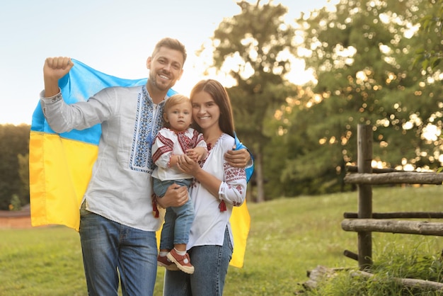 Feliz linda familia con camisas nacionales bordadas con bandera ucraniana en un día soleado Espacio para texto