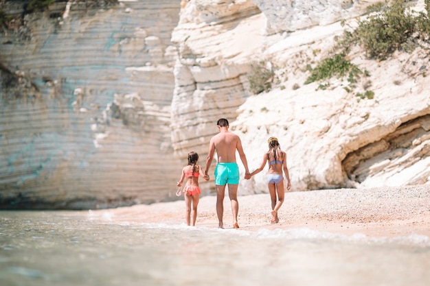 Feliz linda família de pai e filhos na praia branca