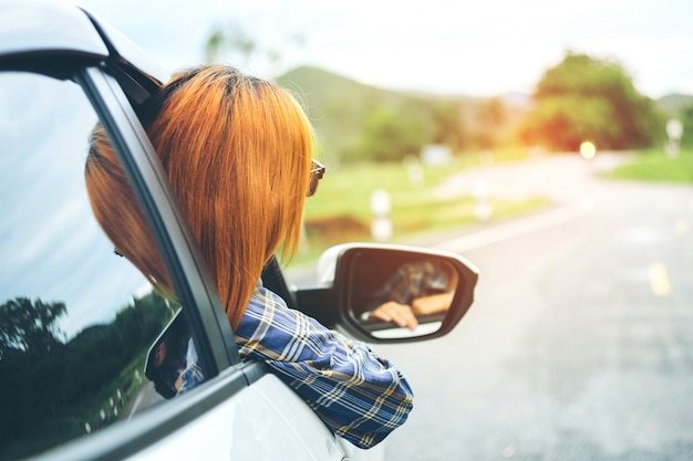 Feliz linda garota viajando em um carro com hatchback