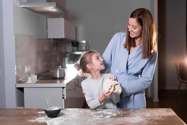 Feliz linda hija y mamá los padres se divierten haciendo galletas cocinando juntos en casa Los padres ayudan al concepto de espacio de copia