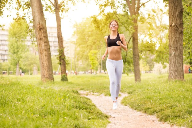 Feliz linda jovem correndo no parque