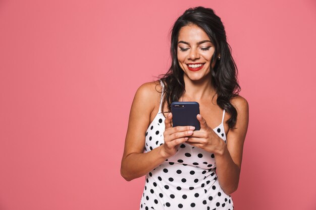 Feliz linda mujer en traje de baño mediante teléfono móvil.