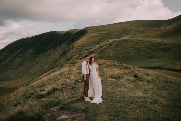 Feliz linda noiva e noivo andando de mãos dadas casal de noivos lindo casal nas montanhas