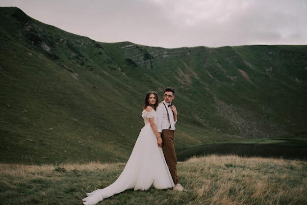 Feliz linda noiva e noivo andando de mãos dadas estilo boho casal de noivos lindo casal nas montanhas com incrível espaço de cenário para texto