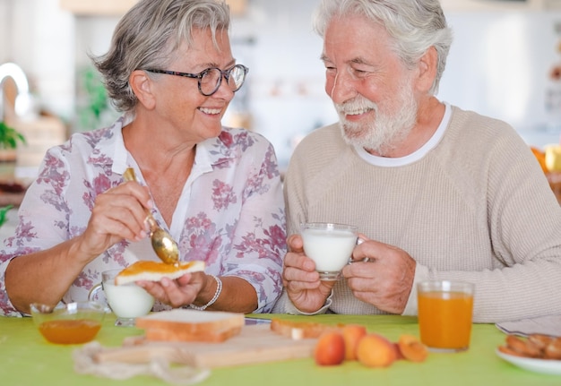 Feliz lindo casal sênior aposentado tomando café da manhã em casa conceito de estilo de vida de felicidade