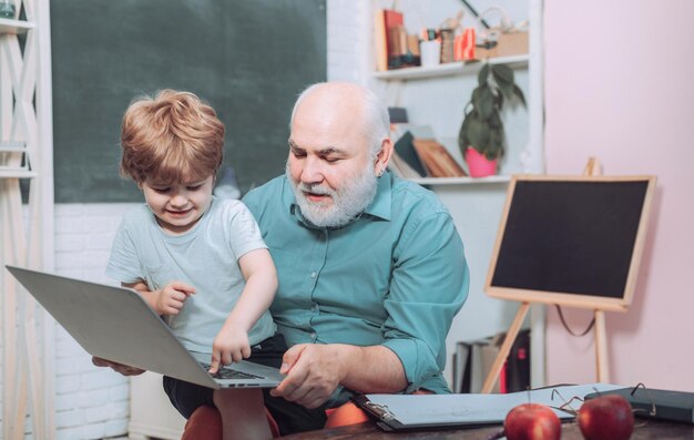 Feliz lindo chico inteligente y viejo tutor con libro Retrato de seguro viejo maestro Aprendizaje y ed.