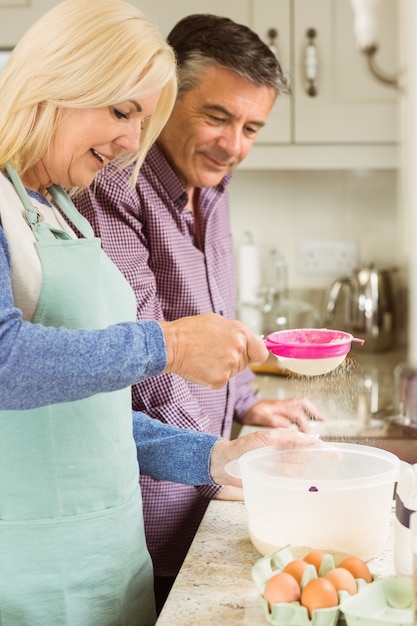 Feliz loira preparando massa com marido