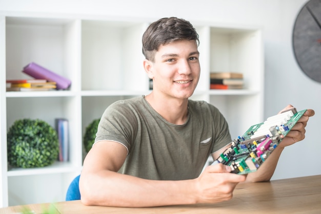 Foto feliz, macho, aquilo, estudante, segurando, motherboard