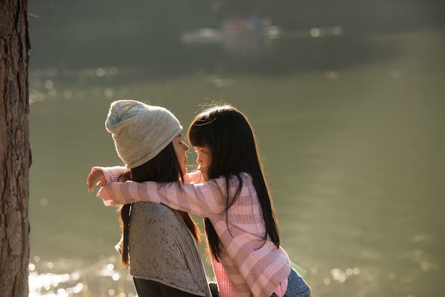 Feliz madre abrazando con su hijo en la naturaleza en un día soleado