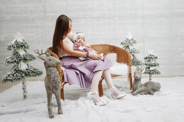 Feliz madre e hija en el árbol de navidad de fondo