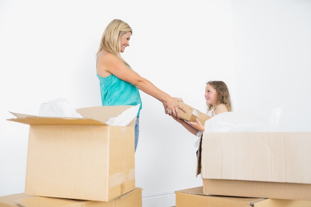 Feliz madre e hija con cajas de mudanza