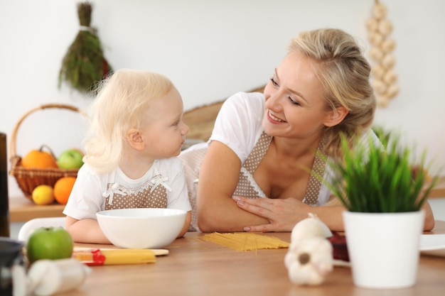 Feliz madre e hija cocinando en la cocina. Pasar tiempo todos juntos, concepto de diversión familiar.