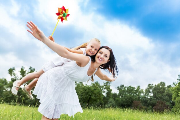 Feliz madre e hija en el fondo de la naturaleza