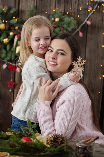 Feliz madre e hija hacen corona de Navidad