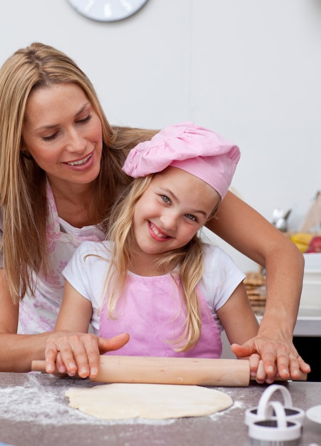 Feliz madre e hija hornear en la cocina