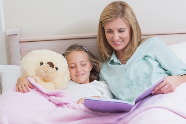 Feliz madre e hija leyendo un libro