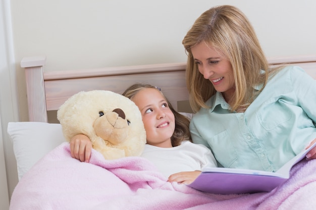 Feliz madre e hija leyendo un libro