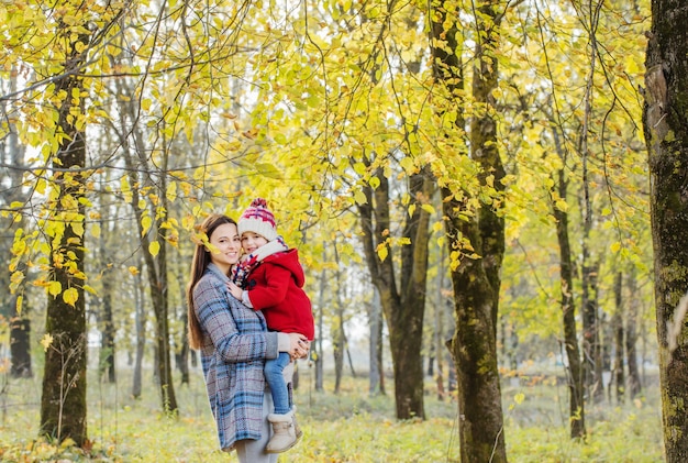 Feliz madre e hija en el parque otoño