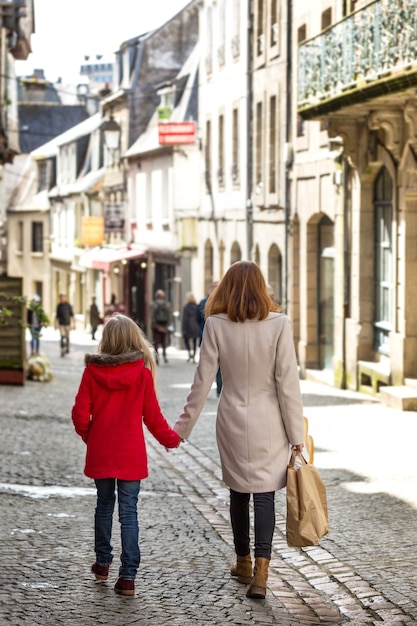 Feliz madre e hija pasean por la ciudad vieja de Morlaix, francia