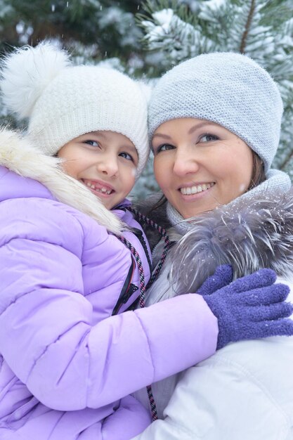 Feliz madre e hija, posando al aire libre en invierno