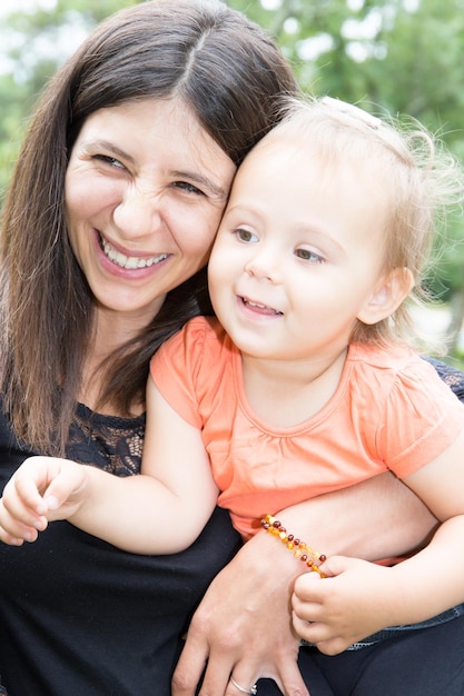 Feliz madre e hija riendo juntas al aire libre