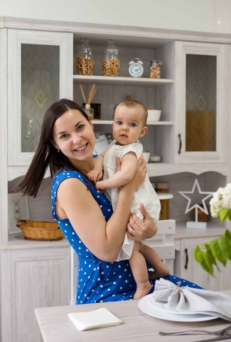 Foto feliz madre e hija sentada en una silla en una mesa en una cocina blanca