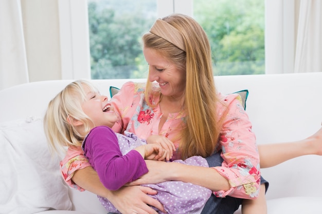 Feliz madre e hija en el sofá