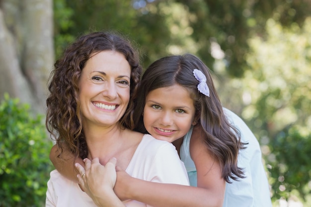 Foto feliz madre e hija sonriendo a la cámara