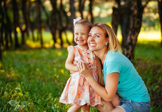 Feliz madre e hija sonriendo a la naturaleza.