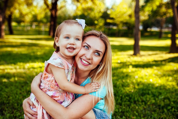 Feliz madre e hija sonriendo a la naturaleza