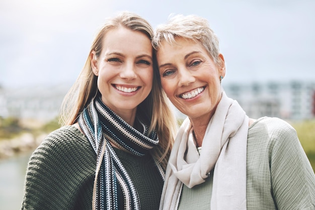 Feliz madre e hija con una sonrisa en la naturaleza juntas en la ciudad de Australia Retrato facial de una mujer joven con una persona mayor en la ciudad o parque junto con amor y para relajarse en la felicidad