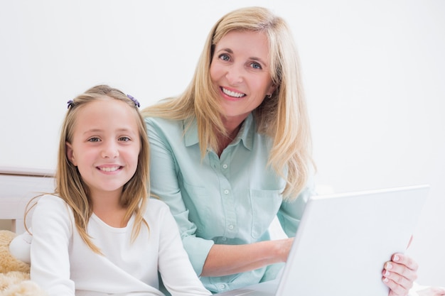 Feliz madre e hija usando laptop