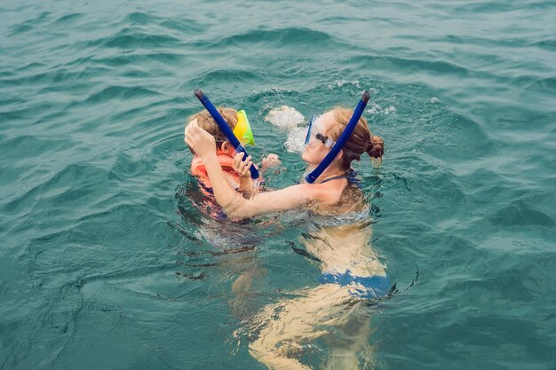 Foto feliz madre e hijo buceando en el barco