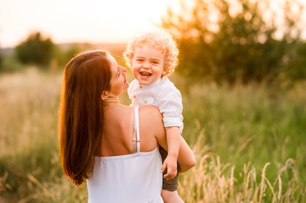 Feliz madre e hijo en el campo al atardecer