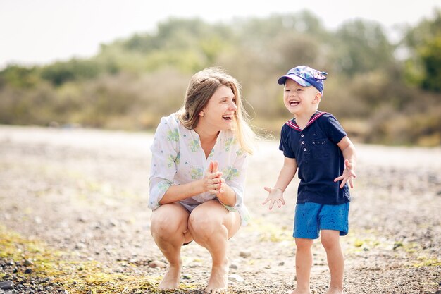 Feliz madre e hijo tienen un rastreo en la playa